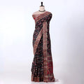 A black and red floral printed saree with intricate gold and red borders