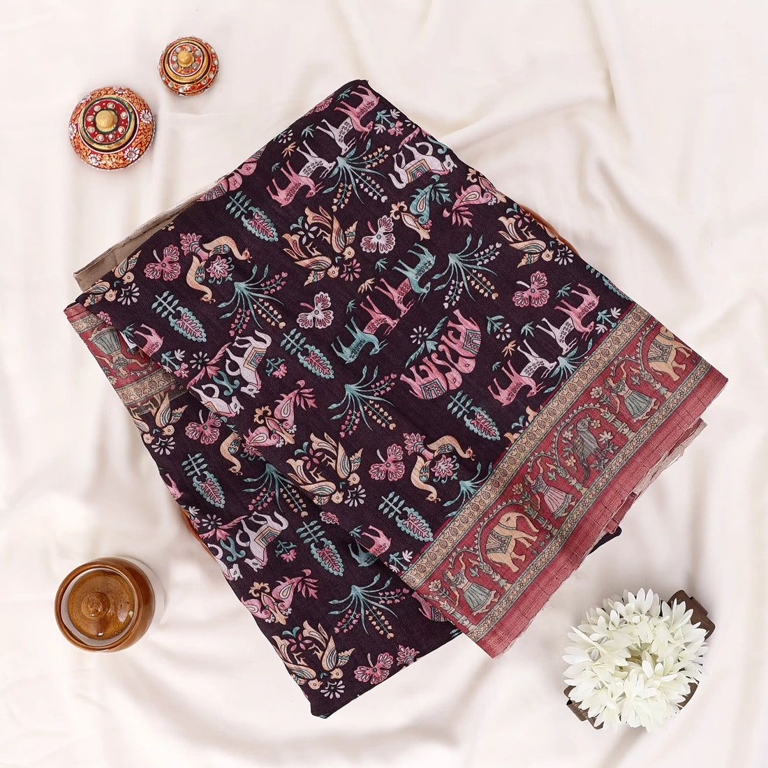A black and red floral printed saree with intricate gold and red borders