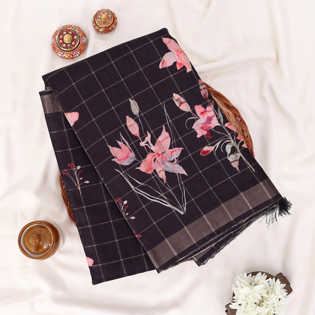 A black and brown plaid saree with pink floral prints