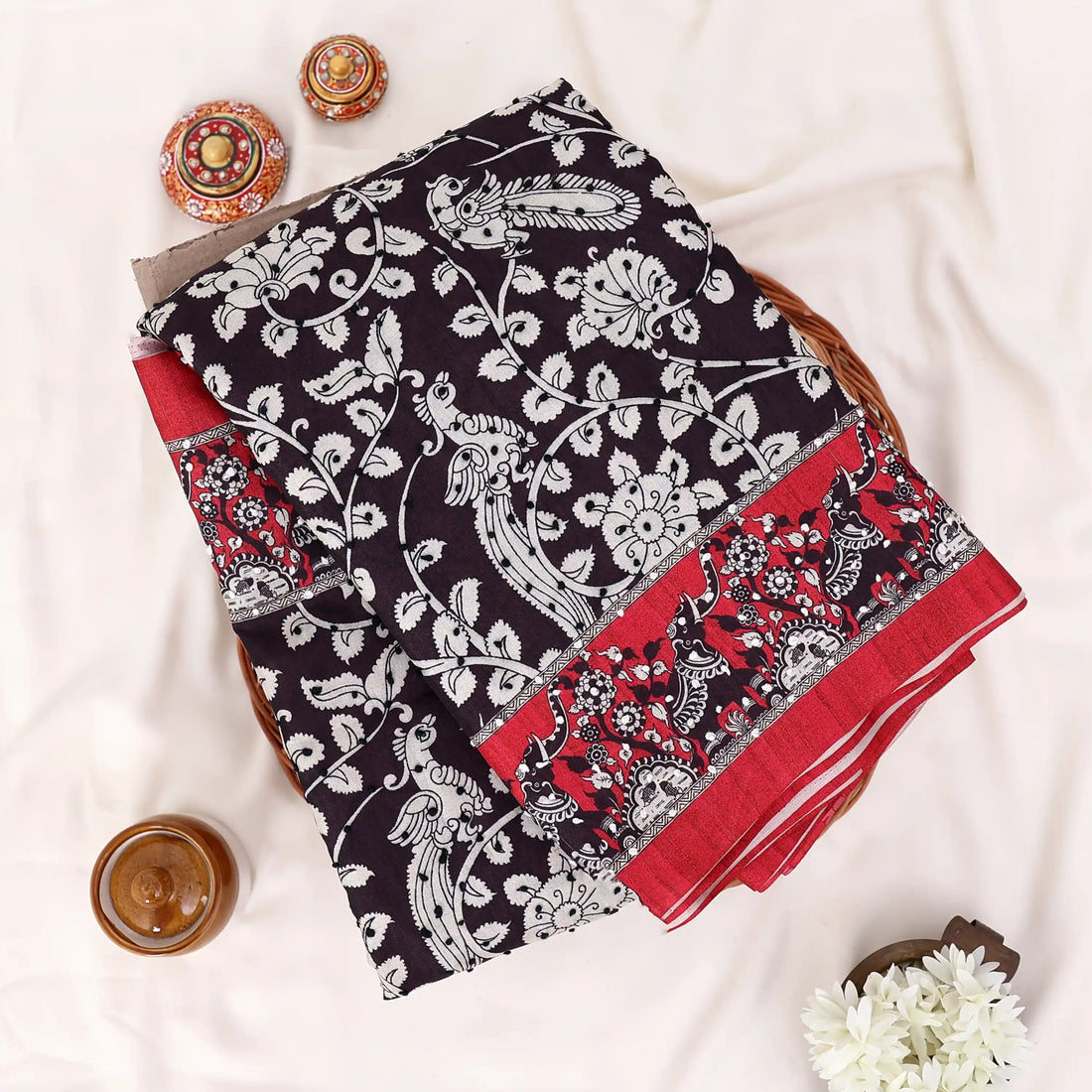 A black and red saree with white floral prints