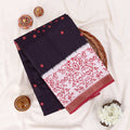 A folded dark navy saree with red floral block print and red border details