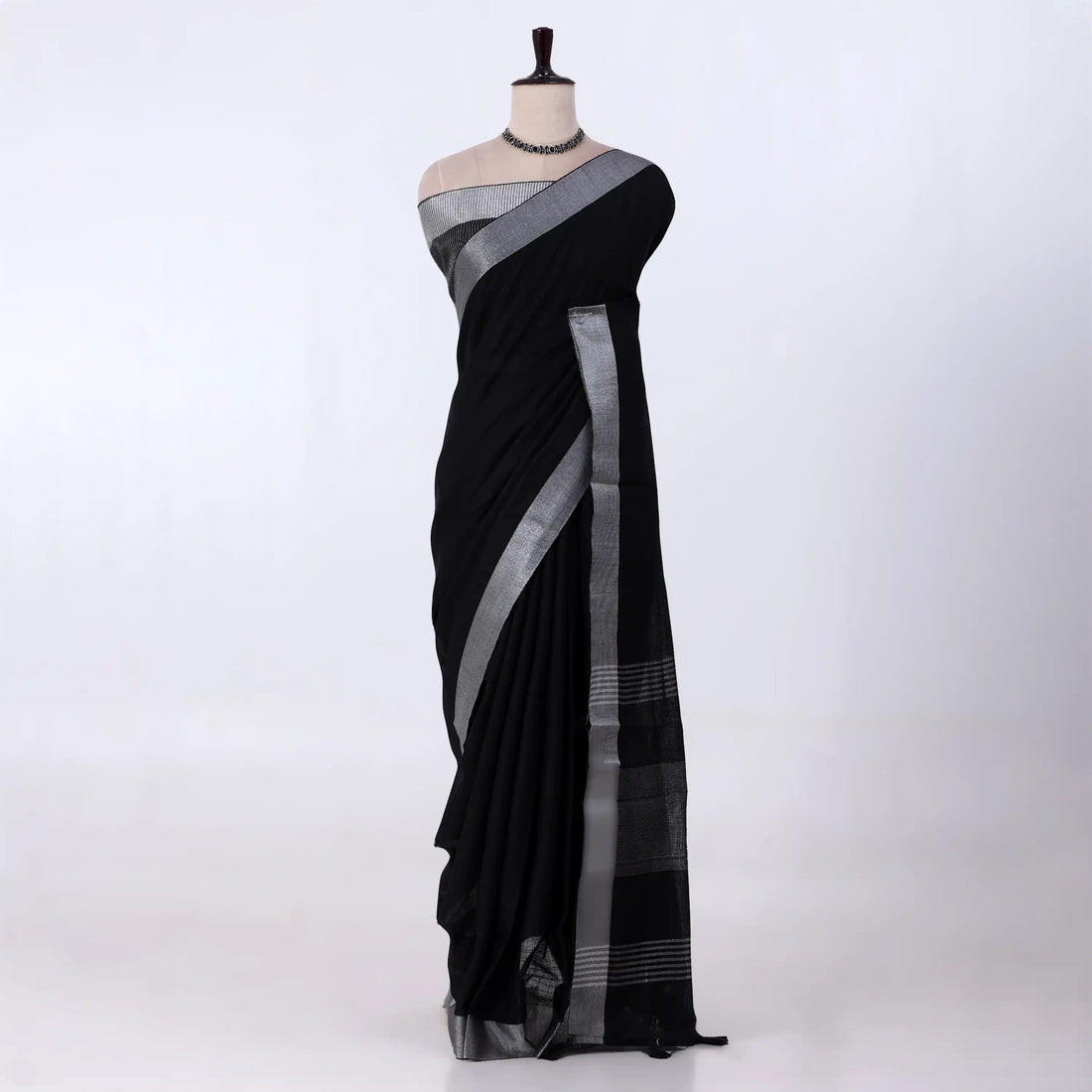 A black saree with a silver-gray border and pallu