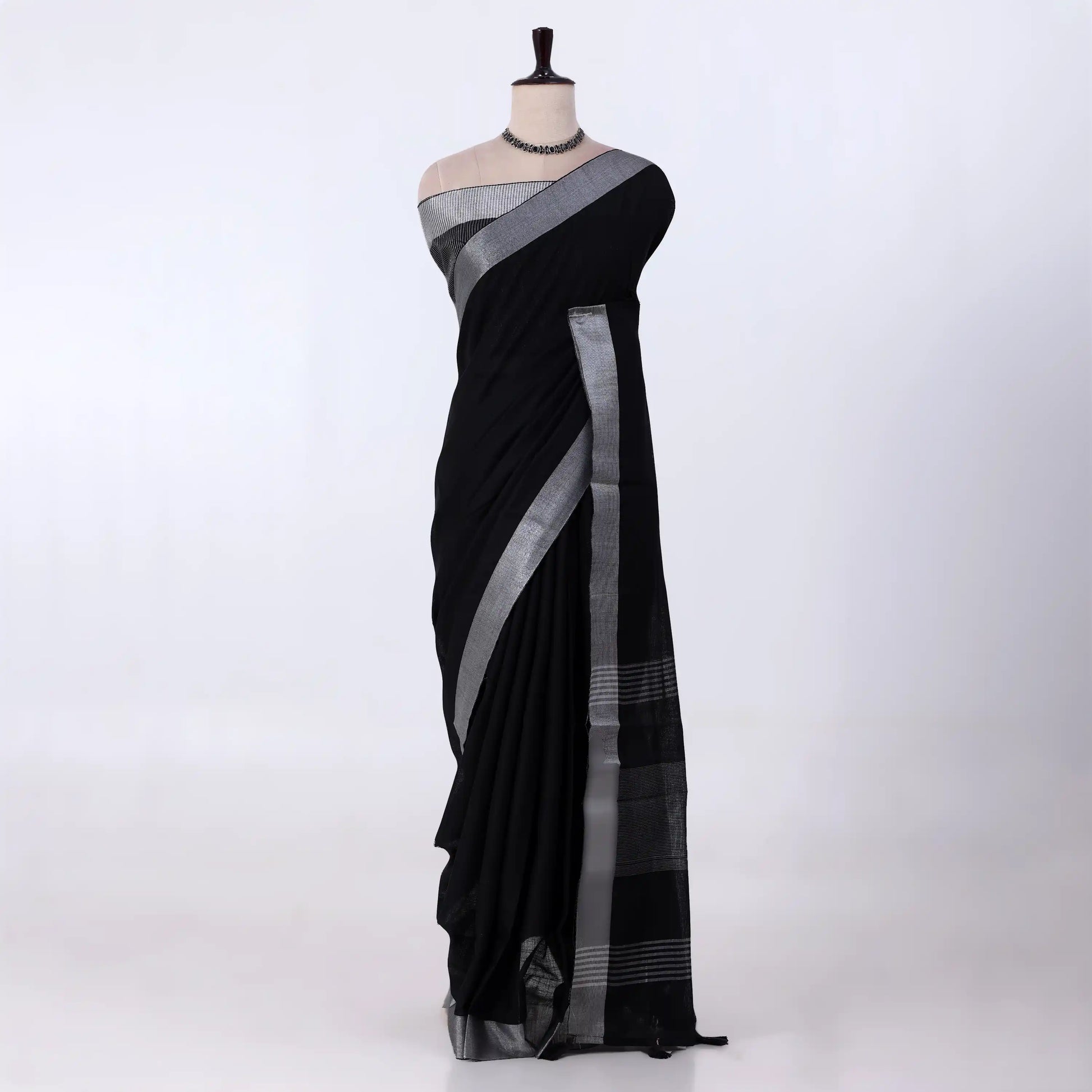 A black saree with a silver-gray border and pallu