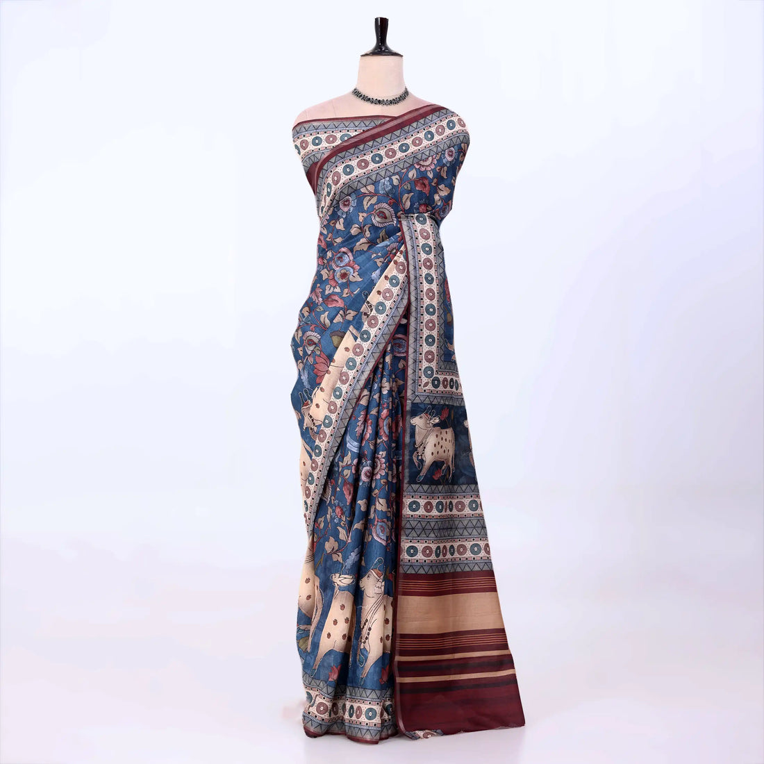 A blue and beige printed saree with traditional motifs and animal illustrations