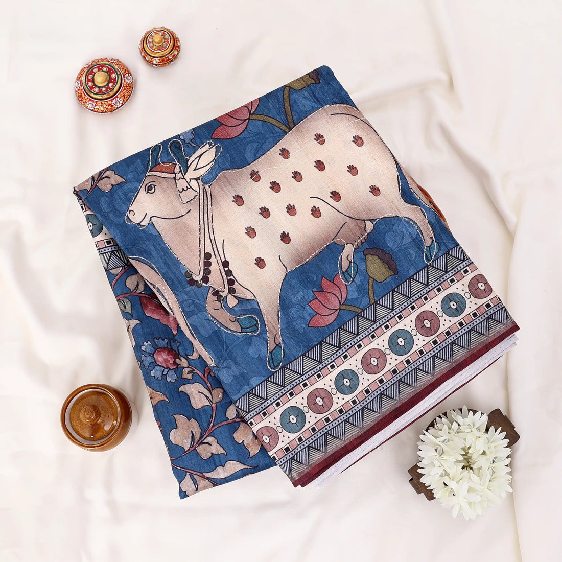 A blue and beige printed saree with traditional motifs and animal illustrations