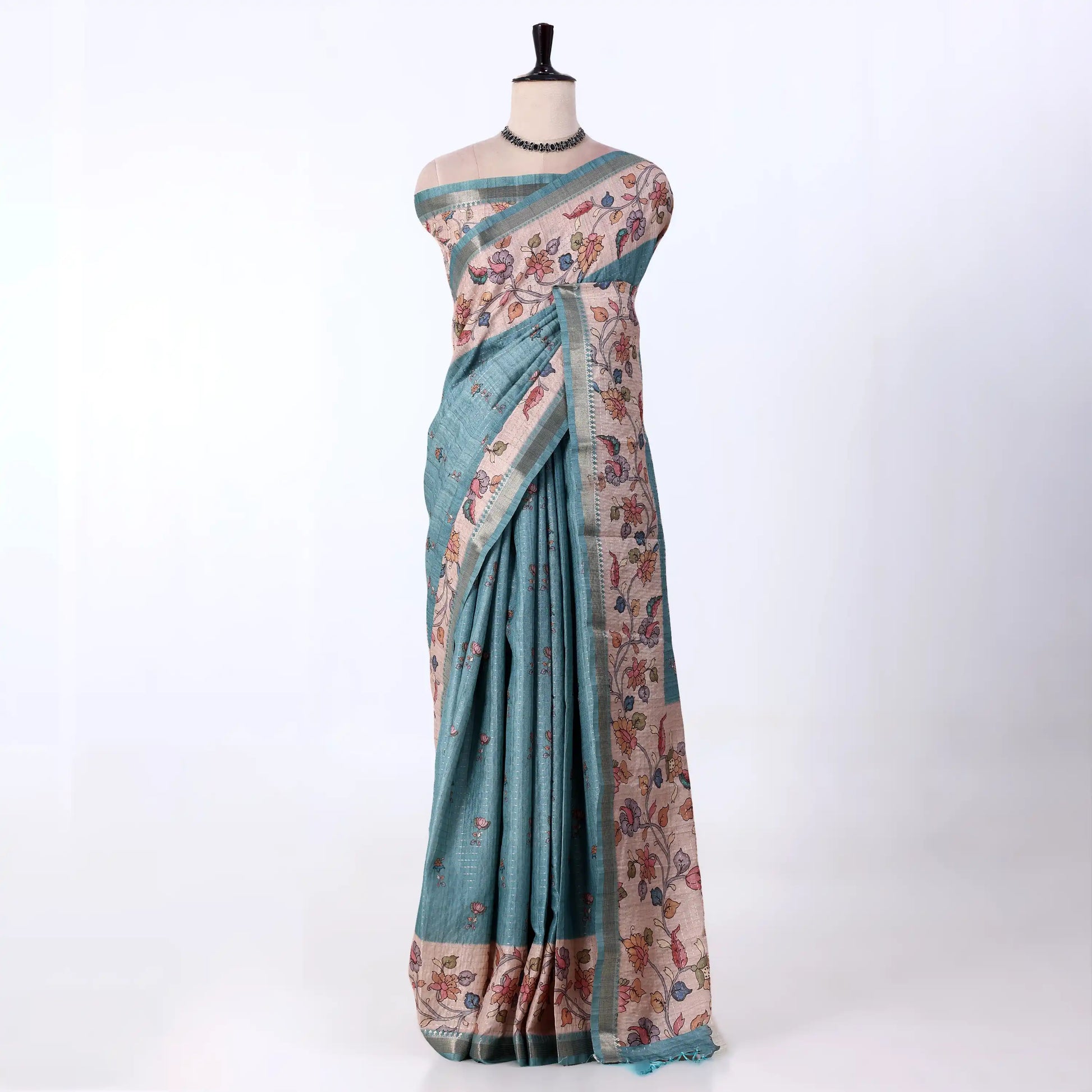 A teal blue and beige printed saree with matching border