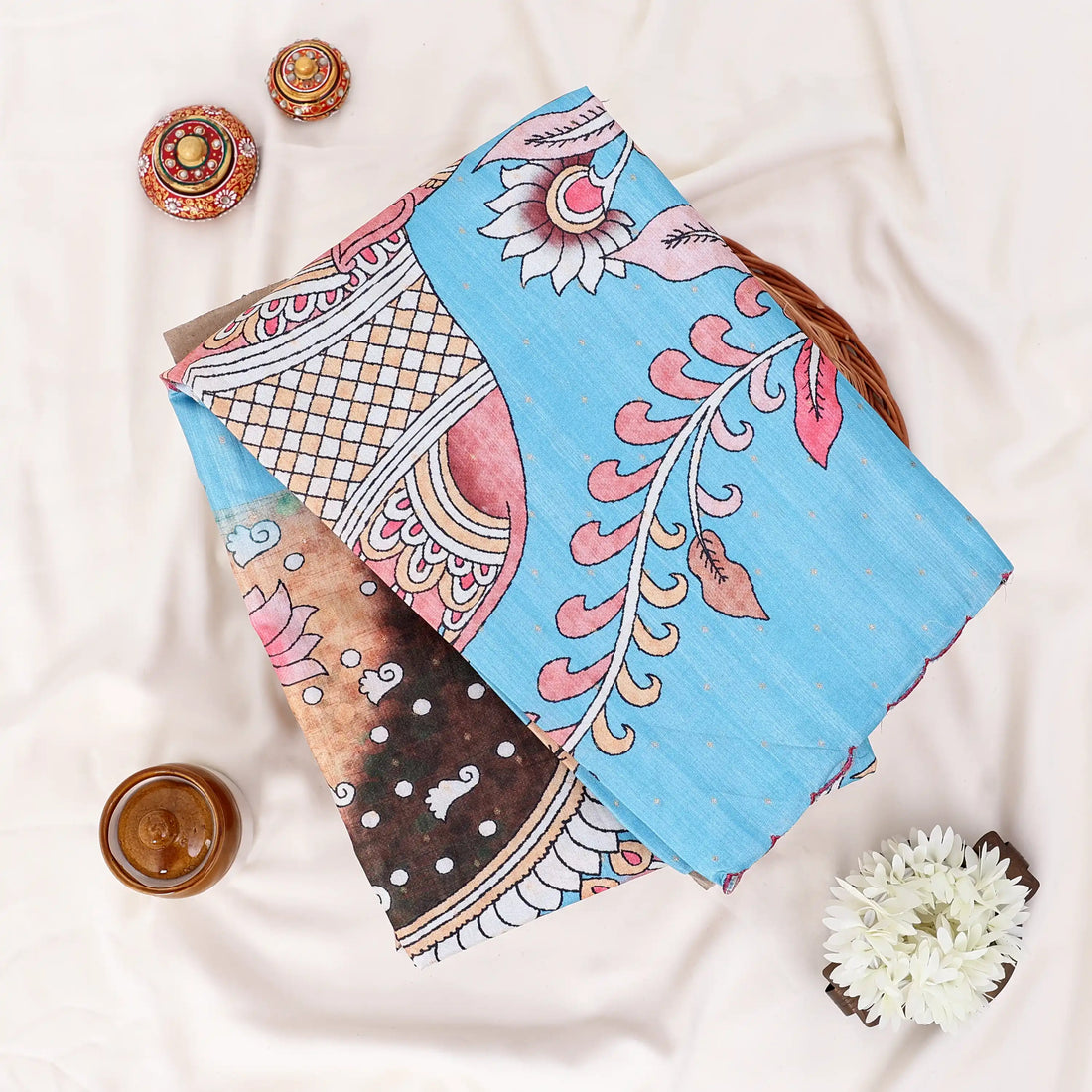 A light blue cotton saree with pink and multicolor traditional prints