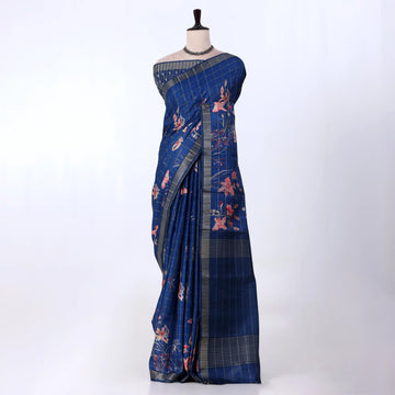 A blue cotton saree with pink floral prints and a gray plaid border