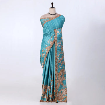 A blue saree with intricate gold and brown paisley patterns