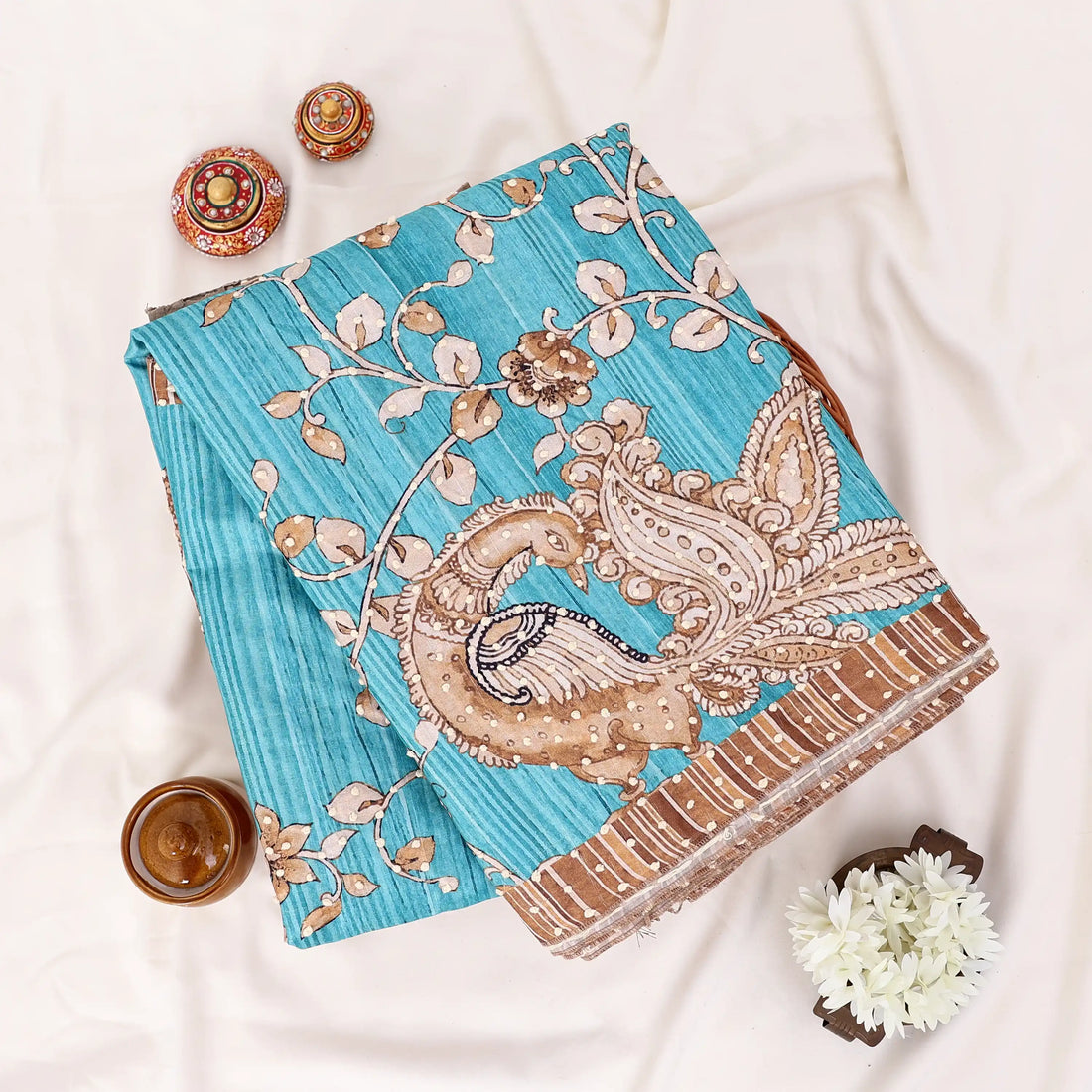 A blue saree with intricate gold and brown paisley patterns