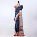 A blue saree with coppery brown borders and white printed patterns