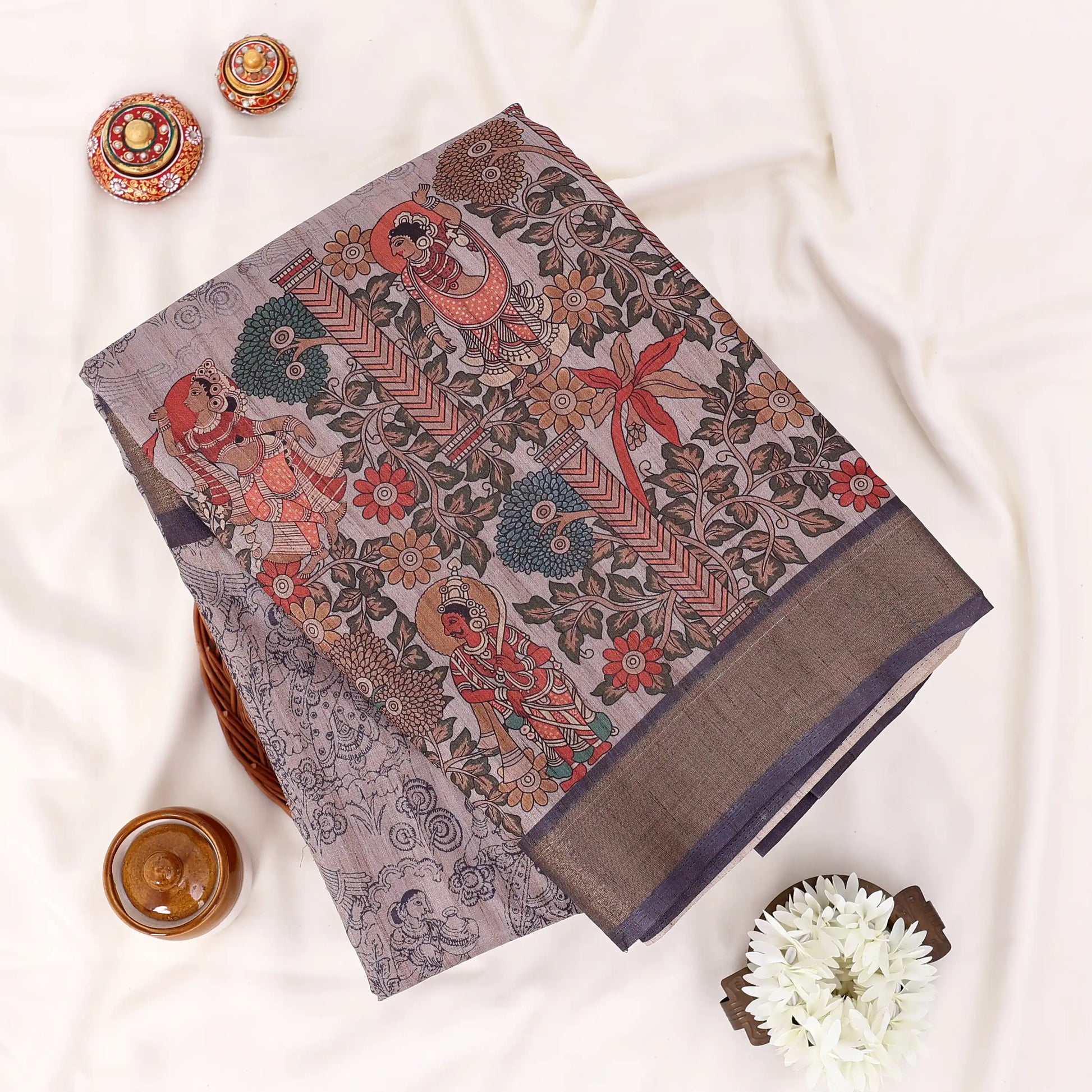 Brown Semi Tussar saree featuring floral print with navy woven border, elegant folded view