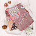 A folded traditional Indian saree with a dusty rose and pink printed design