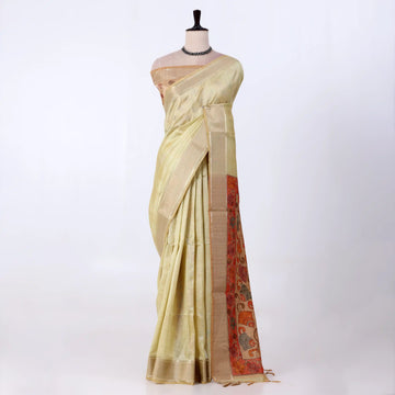 A light yellow saree draped featuring a wide beige border and a red patterned pallu