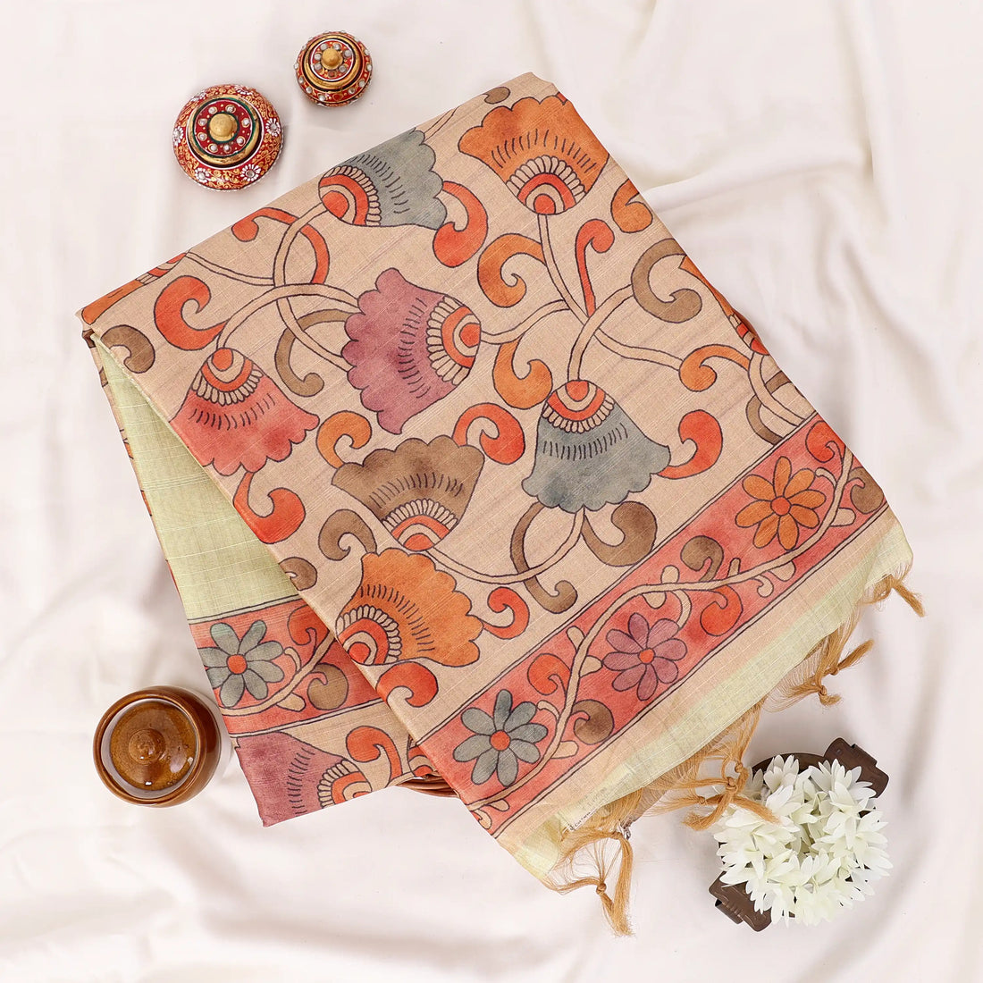 A light yellow saree draped featuring a wide beige border and a red patterned pallu