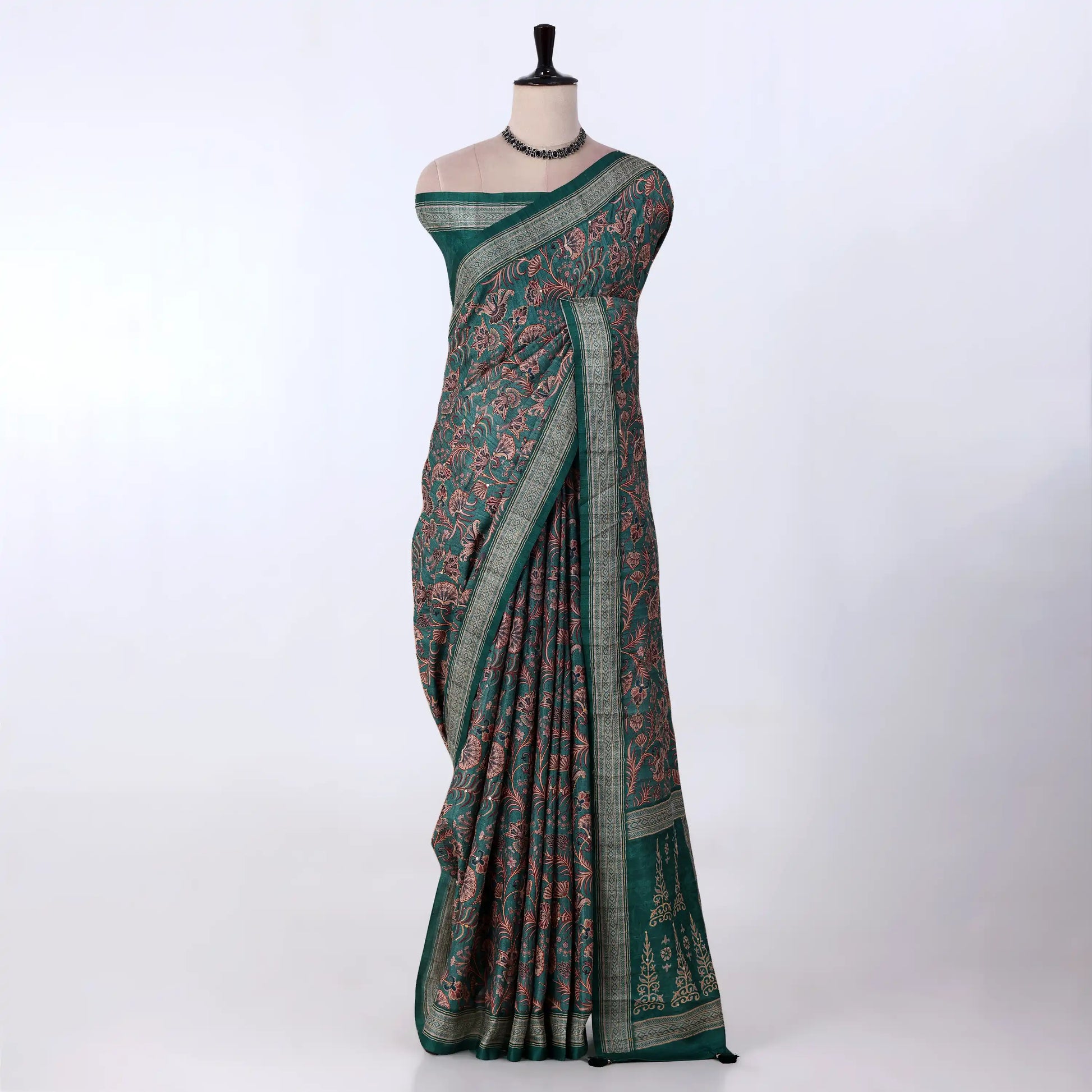 A dark green saree with intricate red and pink floral patterns and a striped border