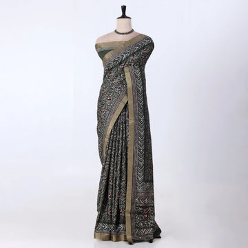 A black and olive green patterned saree with a beige border