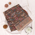 A folded brown fabric piece with a colorful traditional print and decorative border