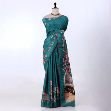 A teal green saree with red and pink floral and bird motifs