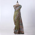 A green and brown printed saree features a sage green body with brown borders and pink floral patterns.