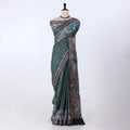 A green and brown printed saree features a sage green body with brown borders
