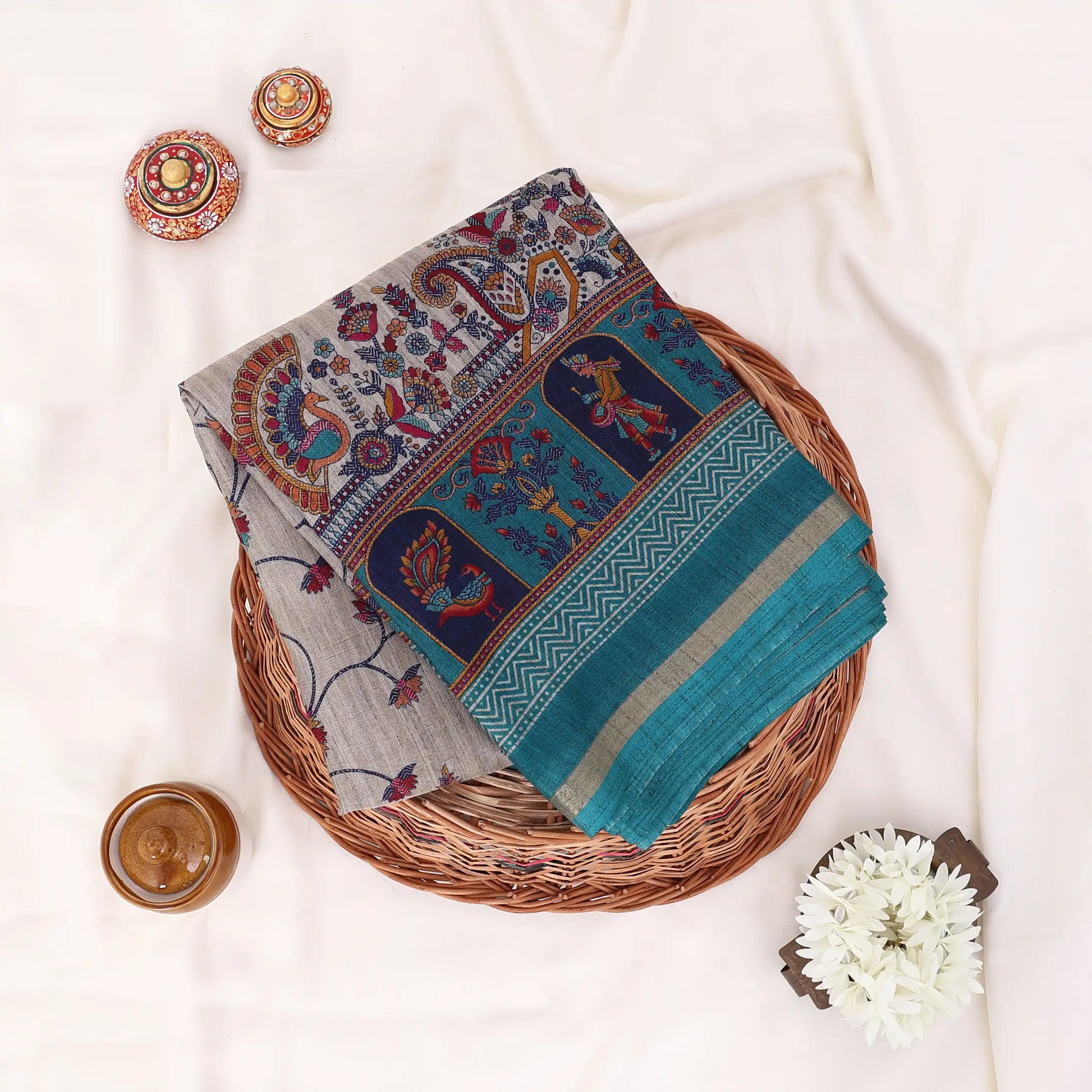 Semi Tussar saree with grey floral printed body and turquoise woven border with decorative pallu.