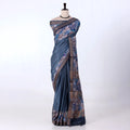 A blue and brown printed saree features a sage blue body with brown borders