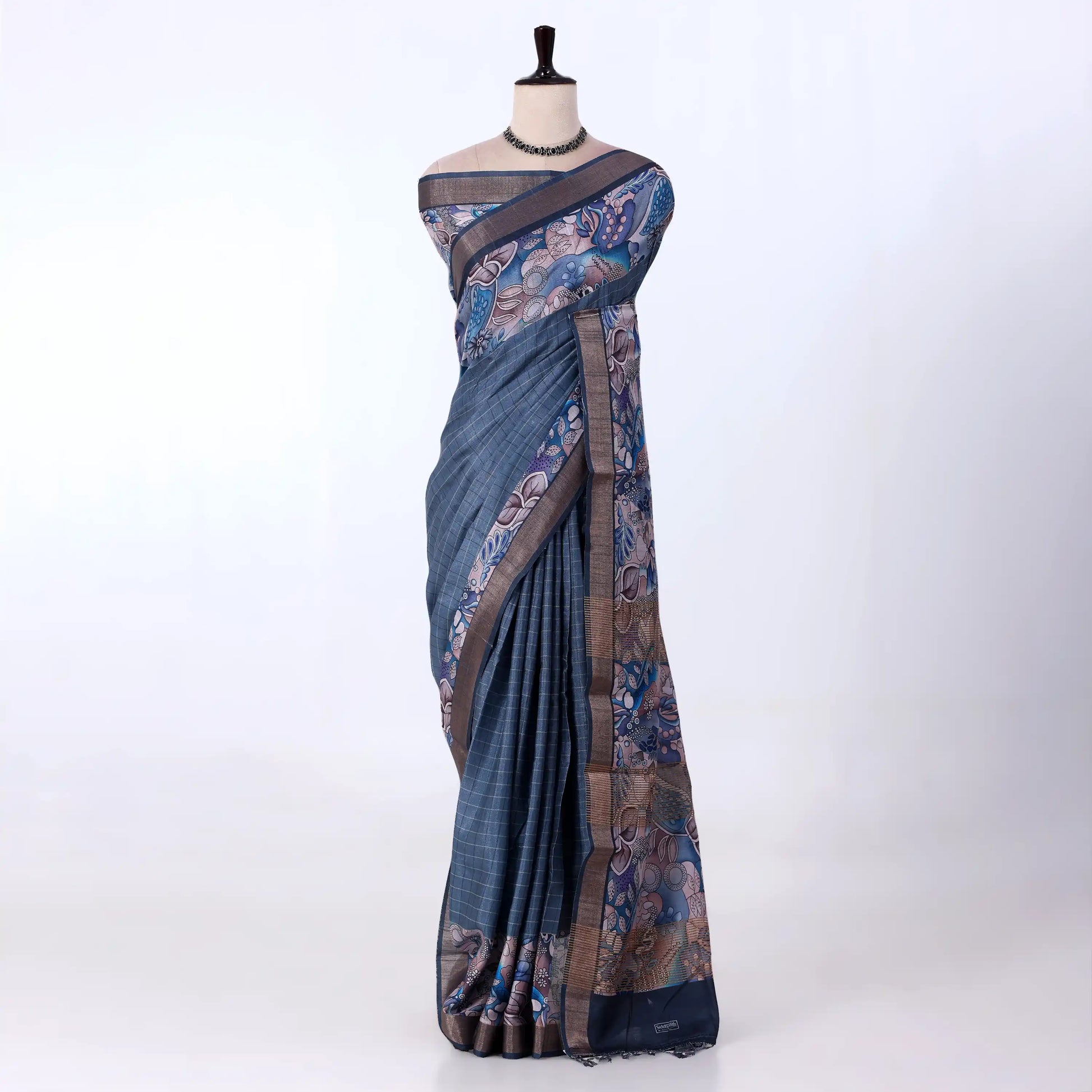 A blue and brown printed saree features a sage blue body with brown borders