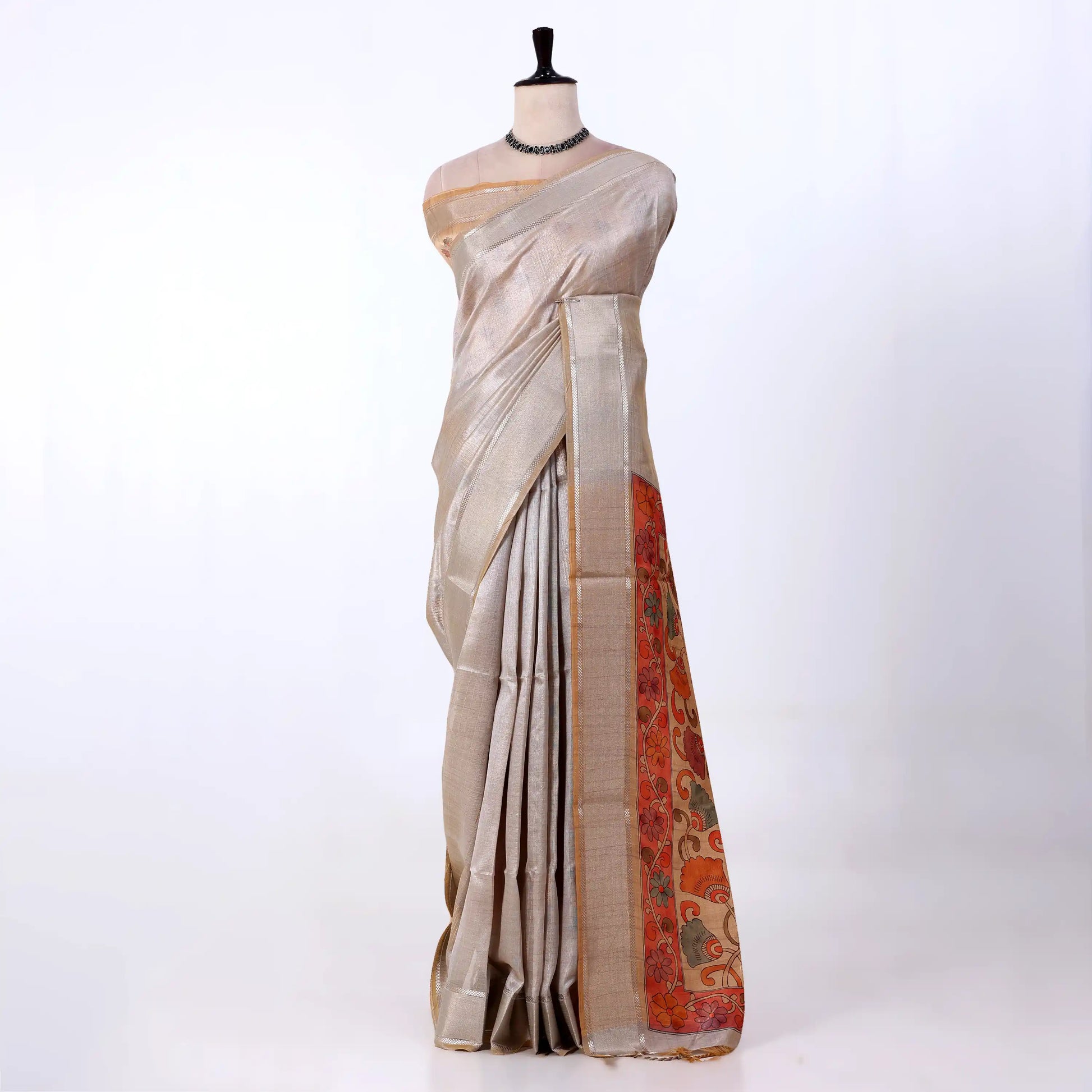 A light beige saree with a vibrant orange and red floral border