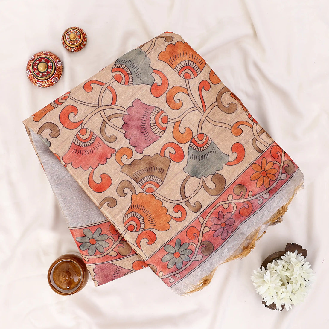 A light beige saree with a vibrant orange and red floral border
