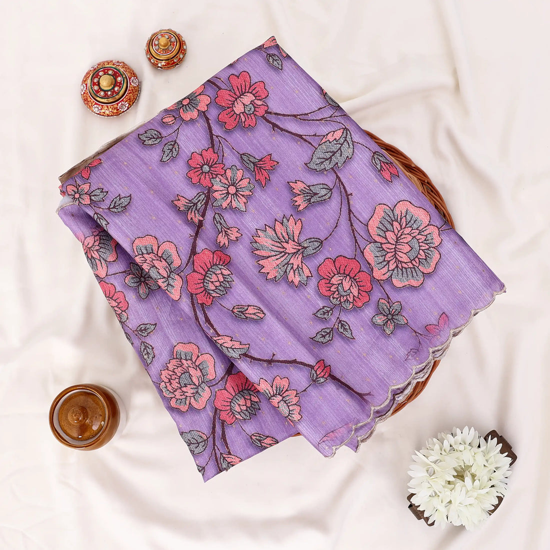 A lavender purple saree with red and orange floral patterns