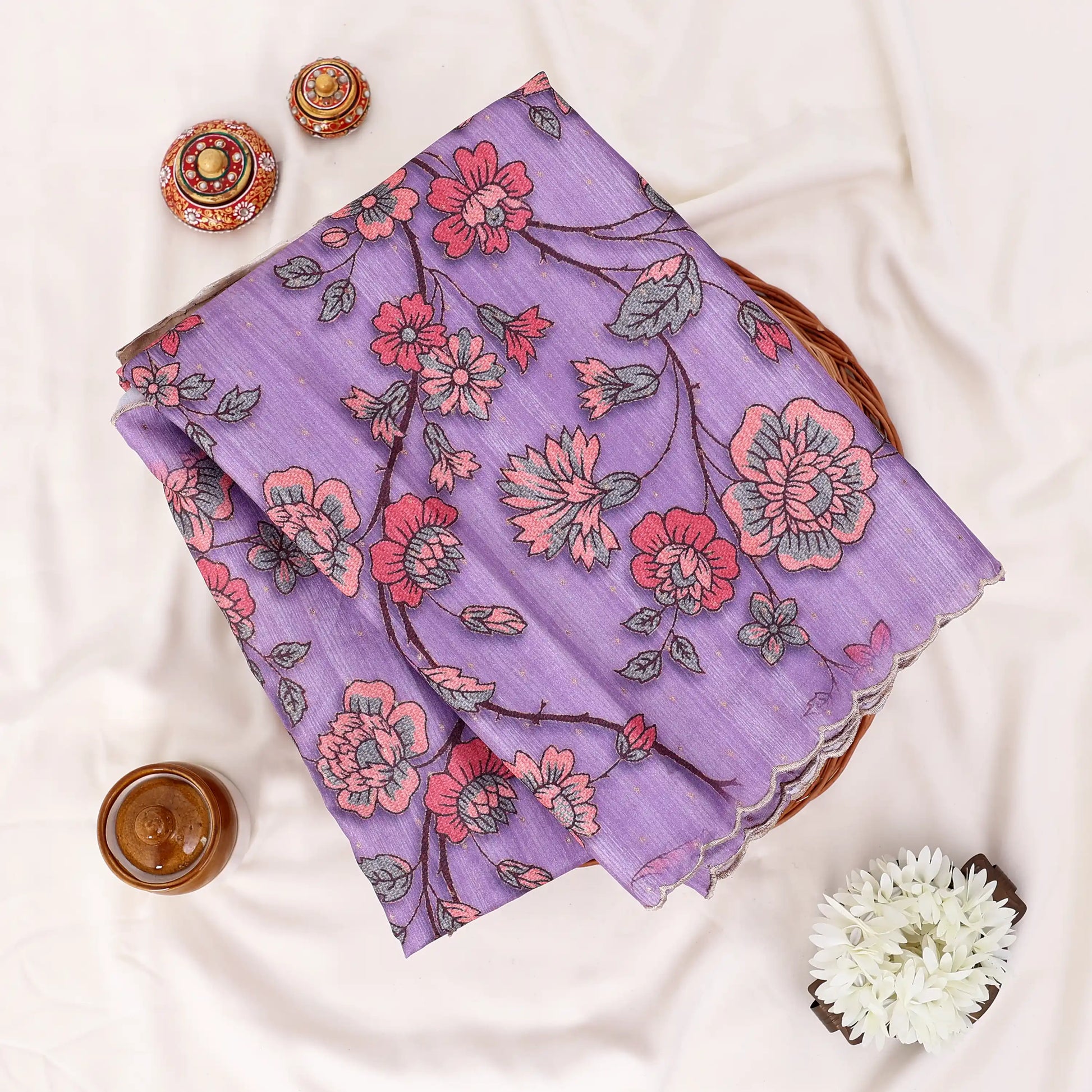 A folded lavender purple scarf with a pink and red floral print