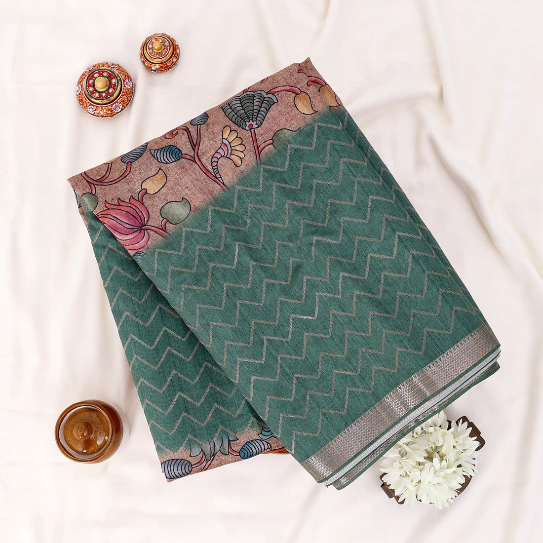 A dark green and black saree with a pink and multicolor printed border