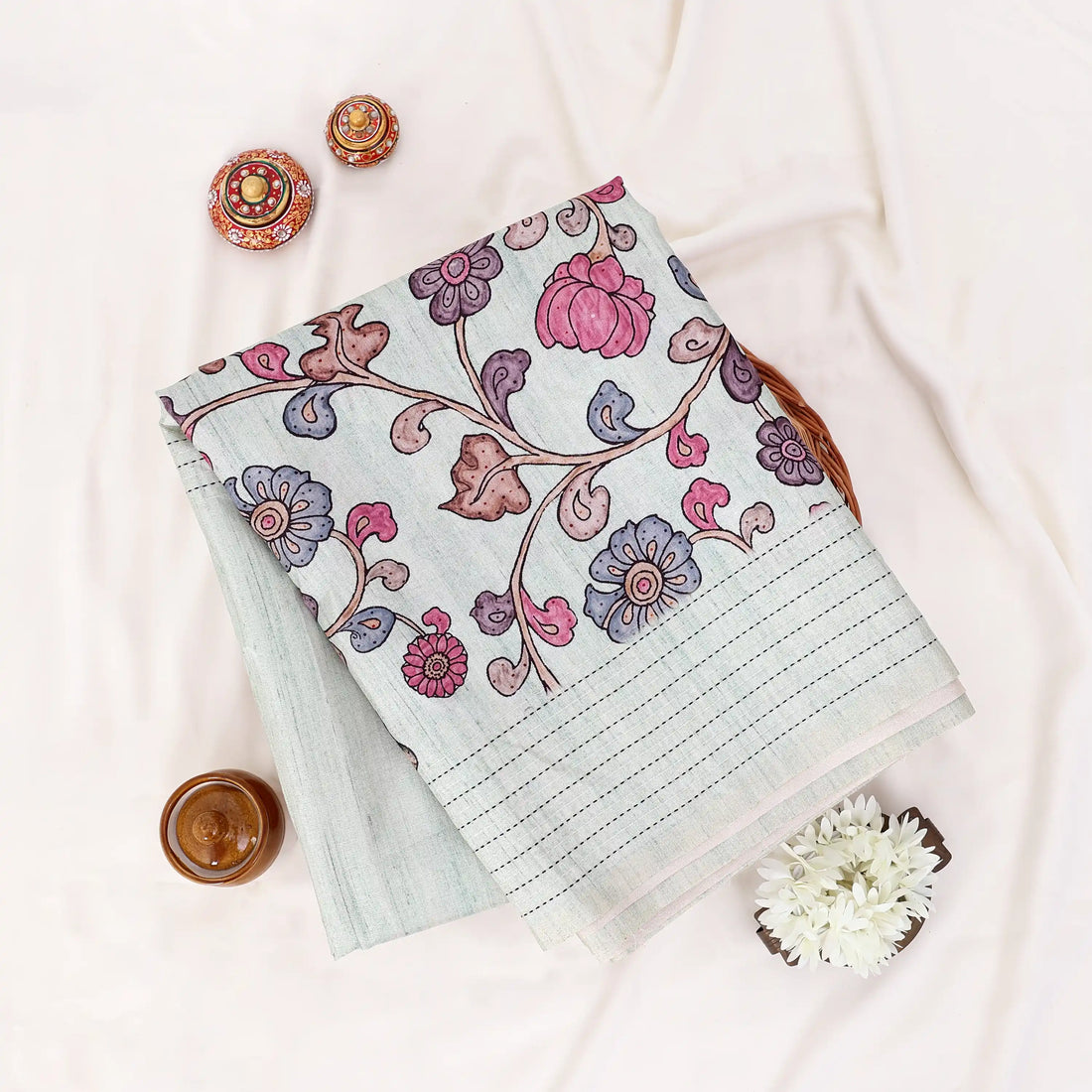 A sage green striped tusser saree with pink and purple floral prints