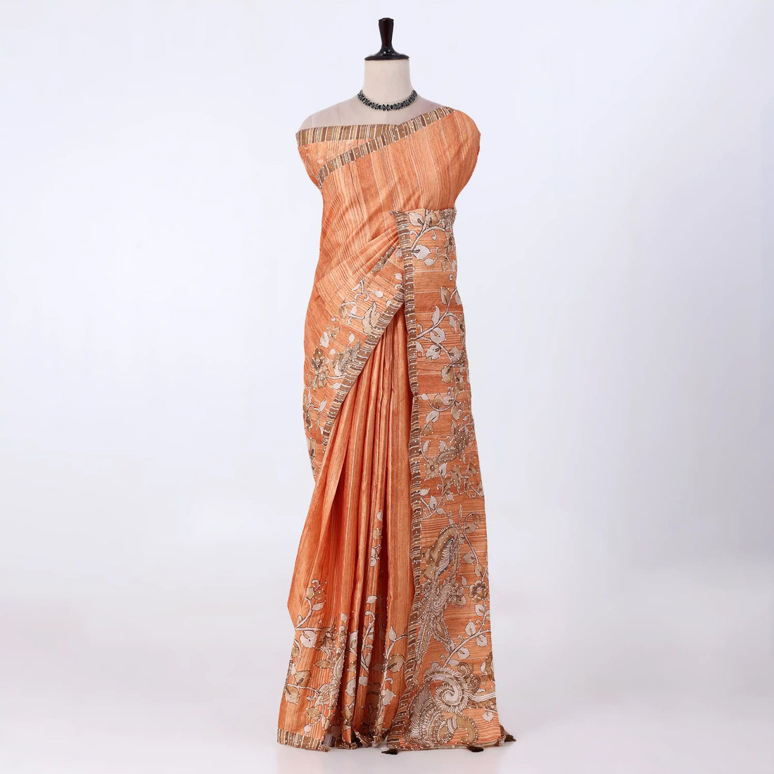 An orange saree with intricate silver and gold floral embroidery