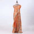 An orange saree with intricate silver and gold floral embroidery
