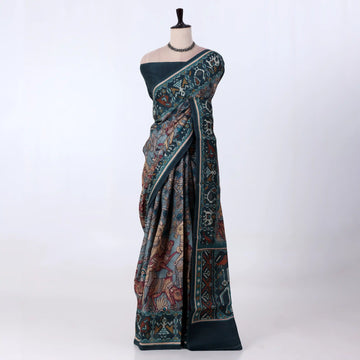 A dark teal saree with intricate multicolor traditional patterns and borders