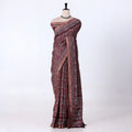 A dark maroon  and gray patterned saree with traditional block prints and a metallic gray border