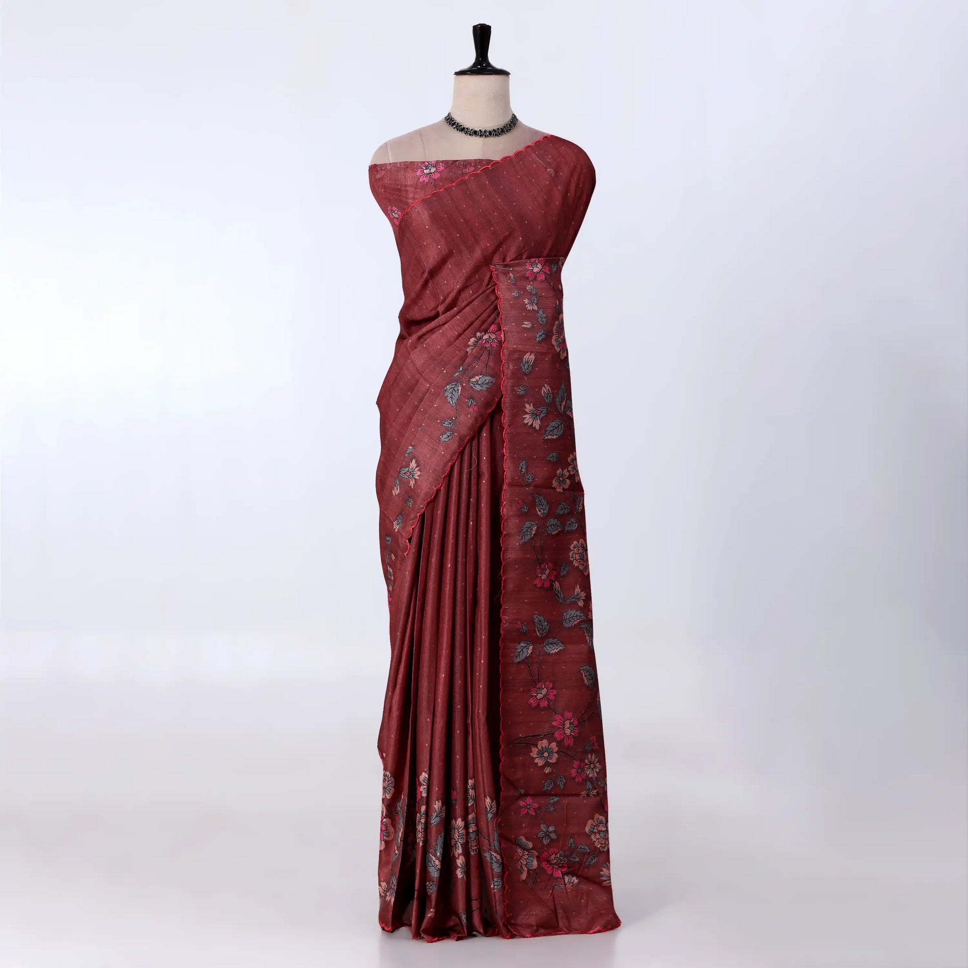 A dark red or maroon saree with floral patterns