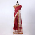 A deep red silk saree with gold zari embroidery and a beige-and-red patterned border