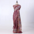 A mauve and pink patterned saree with features a solid mauve border, a floral printed pallu, and a matching printed blouse piece.
