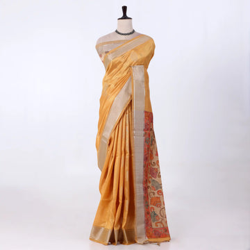 A golden yellow saree featuring a wide beige border and a patterned pallu with red, green, and gold motifs