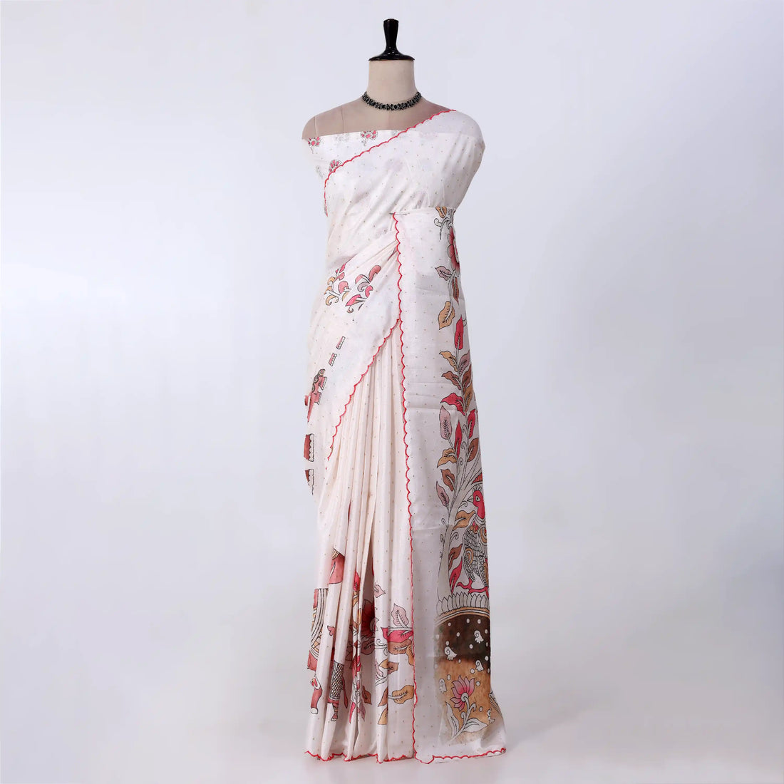 A white and beige printed saree with red border trim and floral motifs