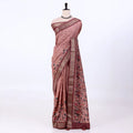 A dusty rose pink tusser saree with black floral motifs and a brown border, draped 