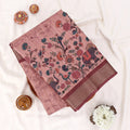 A flat-lay photograph of a dusty pink cotton saree with traditional Indian block prints