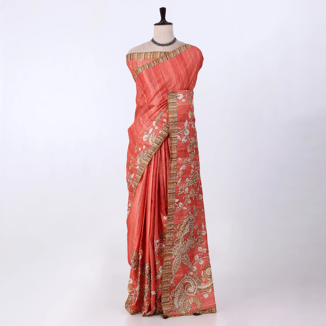 A coral pink saree with gold and silver zari embroidery and border detailing