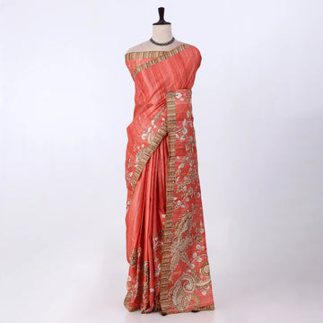 A coral pink saree with gold and silver zari embroidery and border detailing
