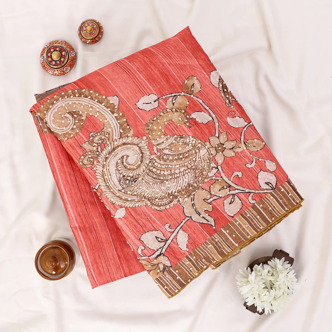 A coral pink saree with gold and silver zari embroidery and border detailing