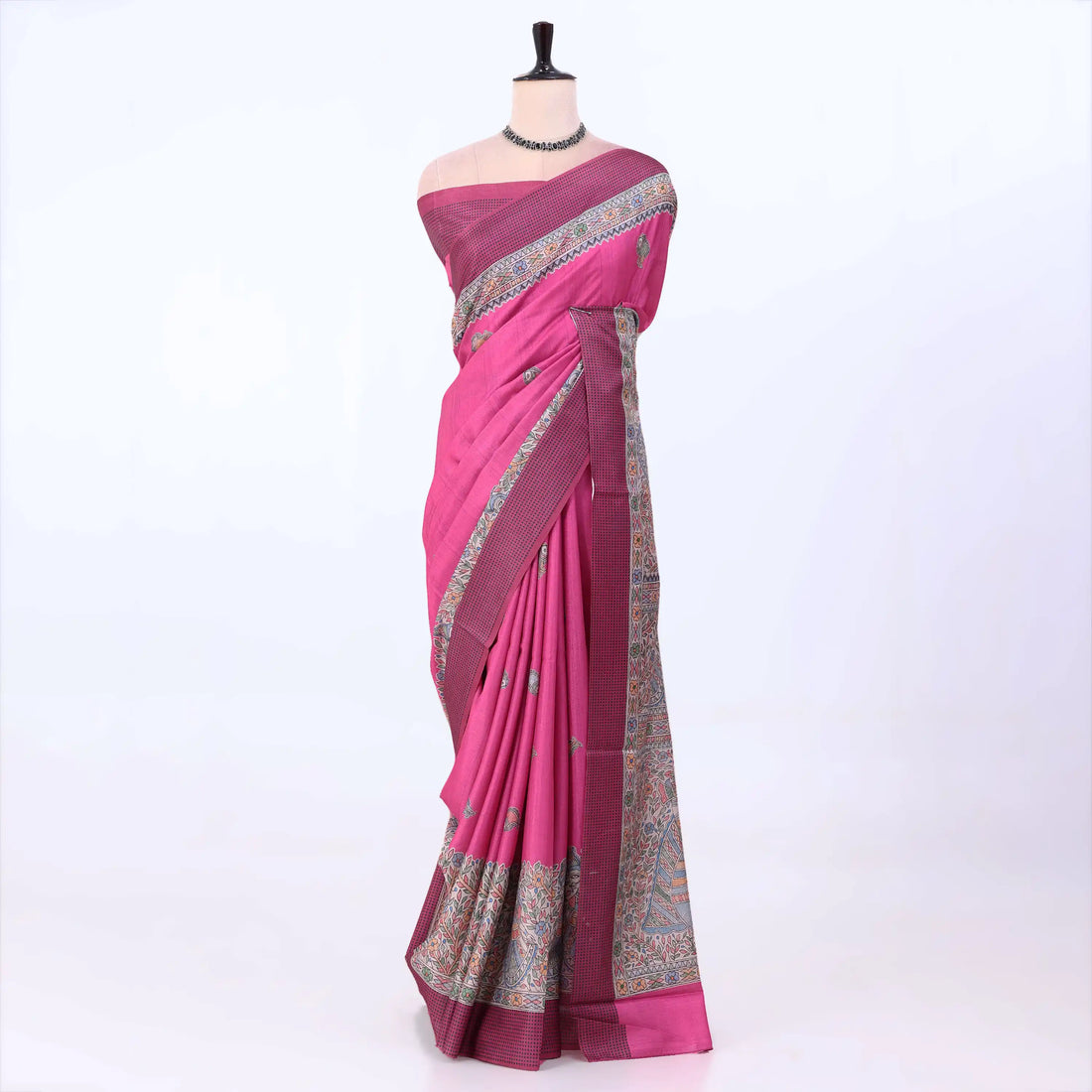 A magenta pink silk saree with a detailed multicolor border