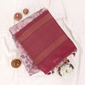 Semi Tussar saree with pink floral printed body and turquoise woven border with decorative pallu top view.